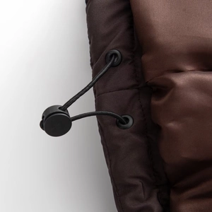 Detail of adjustable drawstring with elastic cord lock and metal eyelet on brown jacket
