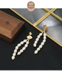 Detailed view of long gold-plated tassel earrings featuring elegant freshwater pearls