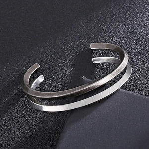 Gros plan de bracelets ouverts en C en argent et finition en acier brossé vintage