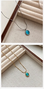 Close-up of gold and silver titanium necklaces with blue cat eye stone pendants