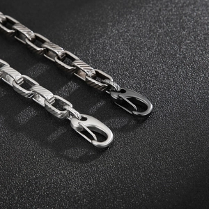 Macro detail of bicolored titanium steel chain links in silver and black with lobster clasp