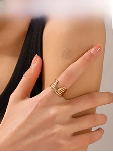 Detail of gold-plated V-shaped multi-layered open ring with grooved industrial texture