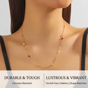 Detail view of thin gold chain necklace with teardrop charms on a female neck
