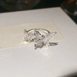 Detailed macro view of silver butterfly ring with hollow wings and cat eye stone inlays