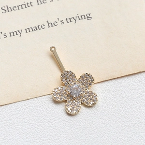 Macro shot of gold floral pendant featuring sparkling white cubic zirconia micro-pave