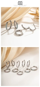Macro view of G23 titanium hinged hoop earrings with colorful inlaid cubic zirconia stones