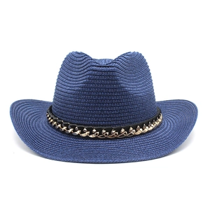 Detalle del sombrero de vaquero de paja azul marino con cinta de cadena dorada