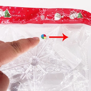 Detail view of a transparent plastic Christmas tree star topper with multicolor LED lights