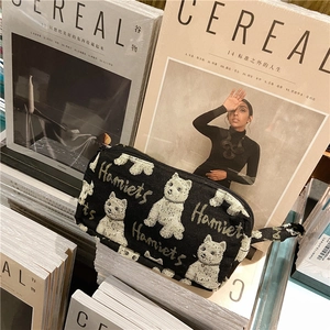 Vue détaillée de la trousse en toile noire avec motif de chien blanc et fermeture.
