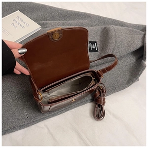 Vue détaillée du sac besace marron montrant les compartiments internes et le fermoir