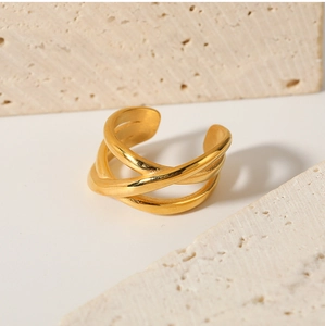 Macro view of multi-layered crisscross 18K gold plated stainless steel ring on stone