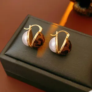 Retro leopard print earrings with gold hooks and white pearls on jewelry box