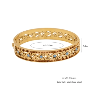 Detailed view of vintage hollow gold stainless steel bangle with blue stone inlays
