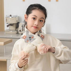 Détail d'une écharpe en maille douce avec jacquard lapin et pompons roses moelleux