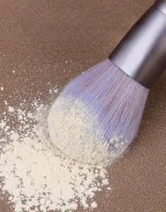 Vue macro des poils denses d'un pinceau maquillage montrant une forte adhérence de poudre