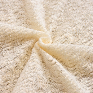 Détail macro du tissu en maille crème montrant la texture respirante et les fibres douces