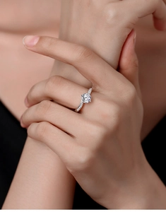 Detail view of a 1-carat round moissanite ring with side stones on a model hand