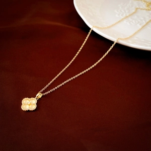 Détails d'un collier en or avec trèfle à quatre feuilles, pierres opales et diamant