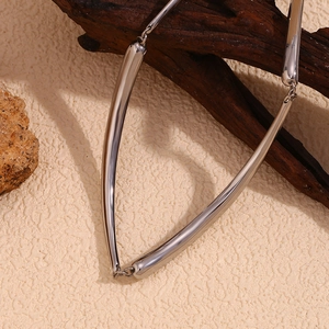 Detailed close-up of a silver-toned bamboo joint chain necklace on a minimalist stone surface