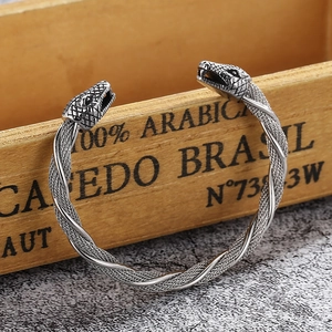 Macro detail of silver double snake head steel cable bracelet with twisted metal texture