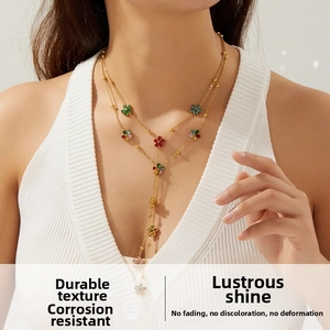 Gros plan du collier en Y doré à double couche avec pendentifs fleurs multicolores