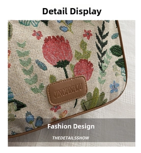 Detailed close-up of vintage floral embroidery and premium leather logo on the shoulder bag