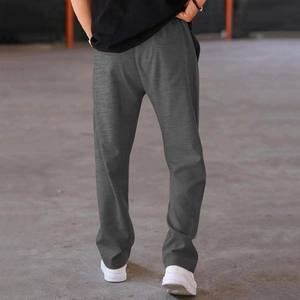 Outdoor shot of men's loose dark gray cotton knit straight leg casual pants from behind