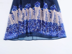 Detailed close-up of flowing chiffon dress hem featuring vibrant blue floral patterns
