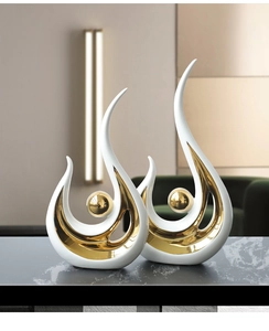 Modern white and gold ceramic phoenix-inspired abstract sculptures on stone tabletop