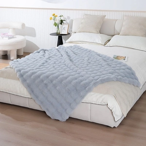 Detail of light blue faux rabbit fur blanket featuring thick 3D wave pattern texture