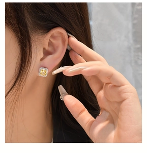 Close-up of 925 sterling silver square yellow diamond stud earring worn on model ear