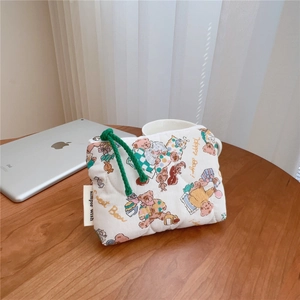 Detailed close-up of small quilted cotton pouch with cute bear patterns and green zipper cord