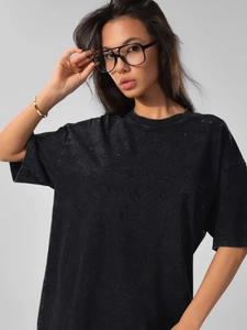 Macro detail of the washed cotton texture and subtle letter patterns on the black t-shirt