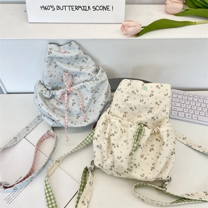Detail of floral canvas backpack with drawstring closure and gingham shoulder straps
