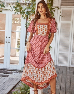 Detail of bohemian floral dress with square neck and ruffled high-low hem in sunlight