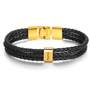 Close-up of triple-layer black leather woven bracelet with gold magnetic clasp and custom name slider