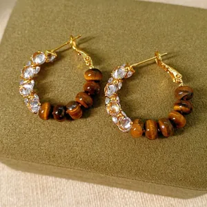 Vintage gold hoop earrings with sparkling zircon and brown tiger eye beads on green box