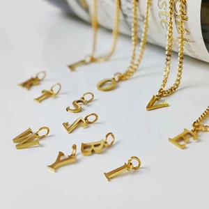 Close-up of DIY gold initial pendants made of polished stainless steel for necklaces