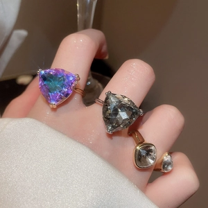Close-up of geometric crystal rings featuring vibrant gradient and clear gemstone facets