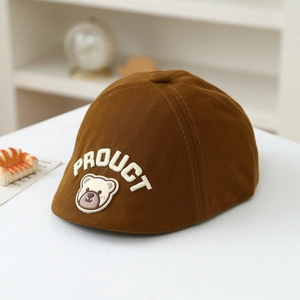 Close-up of caramel brown kids beret featuring embroidered bear and letter logo details