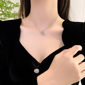 Minimalist silver interlocking double circle pendant necklace on a female model