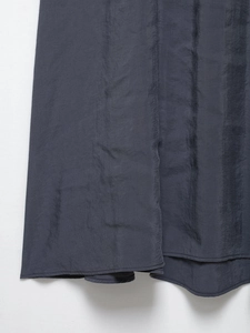 Detail of high-quality silk-like fabric with smooth texture on a dark grey A-line dress hem