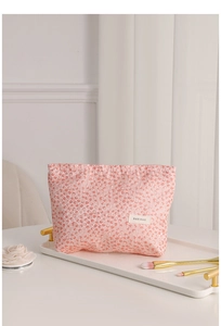 Detailed macro view of pink floral travel makeup bag with H&R BAG woven label on tray