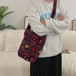 Detail view of plush tote bag featuring colorful geometric ethnic patterns and wide strap