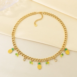 Détail d'un collier en acier inoxydable doré avec des charms ananas et perles