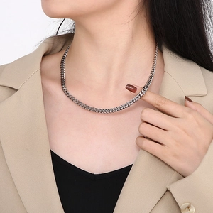 Men's silver-toned stainless steel Cuban link chain necklace worn with a suit
