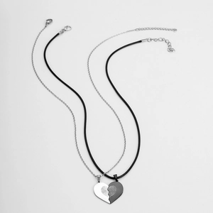 Macro shot of interlocking heart pendants with engraved fingerprints on steel necklaces