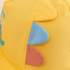 Macro detail of toddler sun hat with 3D colorful dinosaur spines and fine stitching