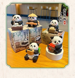 Detailed view of resin panda ornaments with traditional Chinese themed gift boxes