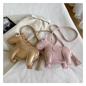 Detail of horse-shaped crossbody bags in pink and gold with litchi texture and metal tassel